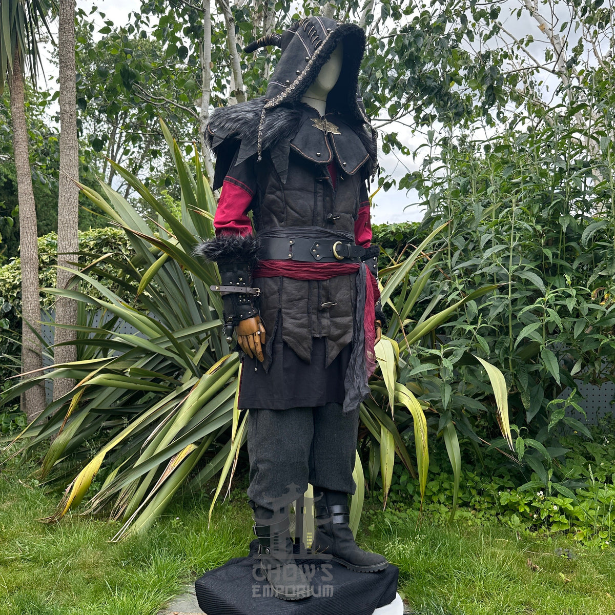 Medieval LARP outfit side view, featuring an ornate hood, waistcoat, tunic, trousers, vambraces.