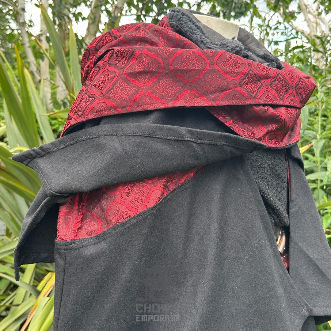 Close-up of red lining and layered collar on black LARP cloak, medieval fantasy cosplay costume.