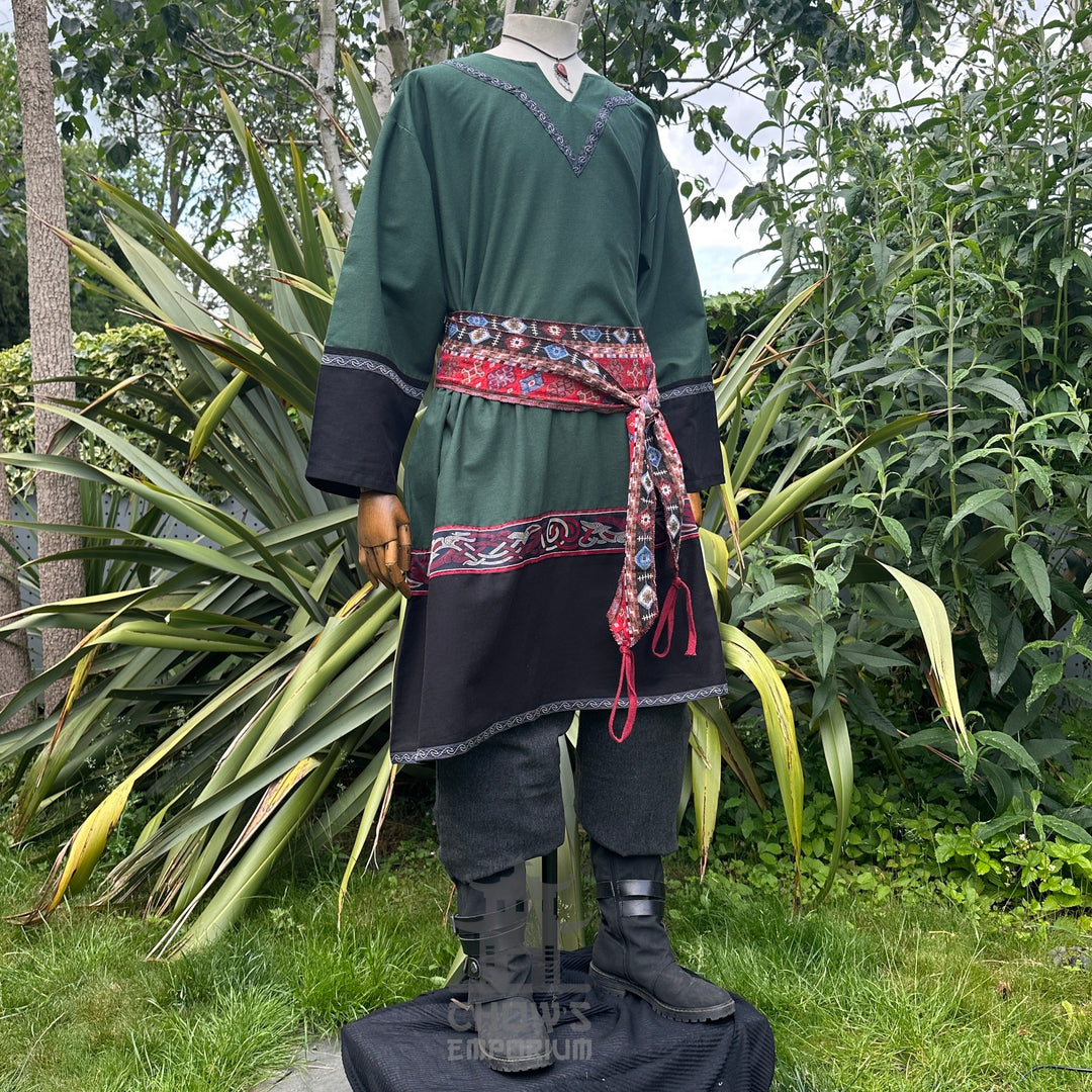 Medieval LARP outfit side view, featuring a green and black Viking tunic, trousers and sash.