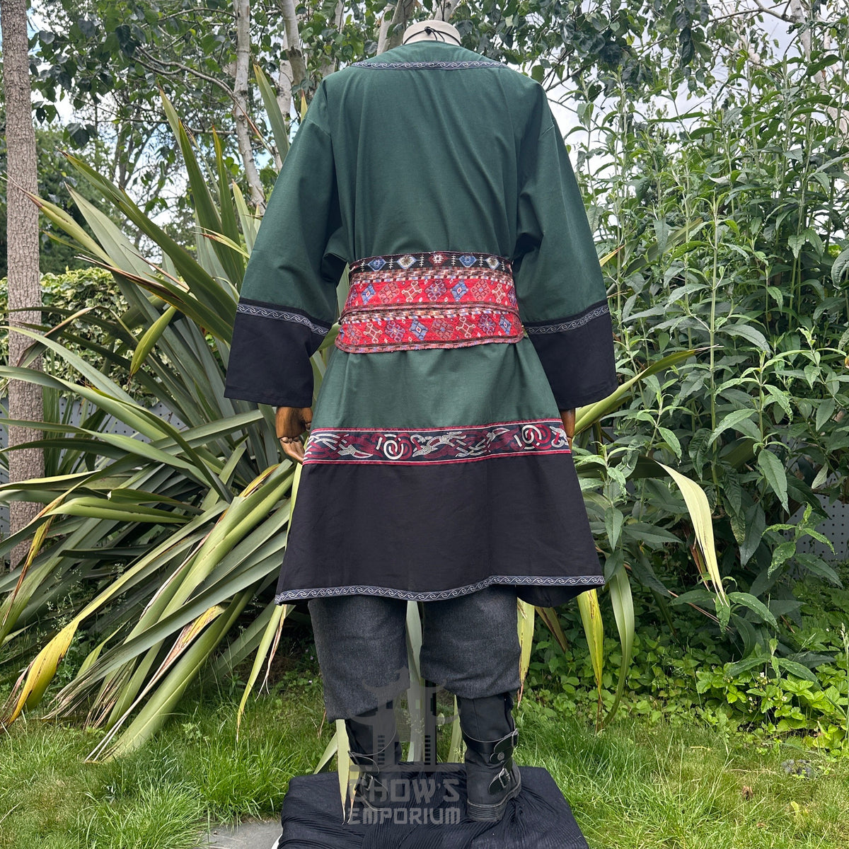 Medieval LARP outfit back view, featuring a green and black Viking tunic, trousers and sash.