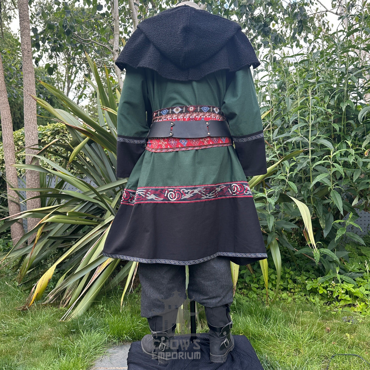 Medieval LARP costume back view featuring a green and black tunic, wool hood, trousers and sash.
