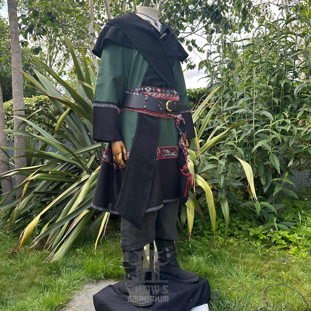 Medieval LARP outfit side view, featuring a green and black Viking tunic, hood, trousers and sash.