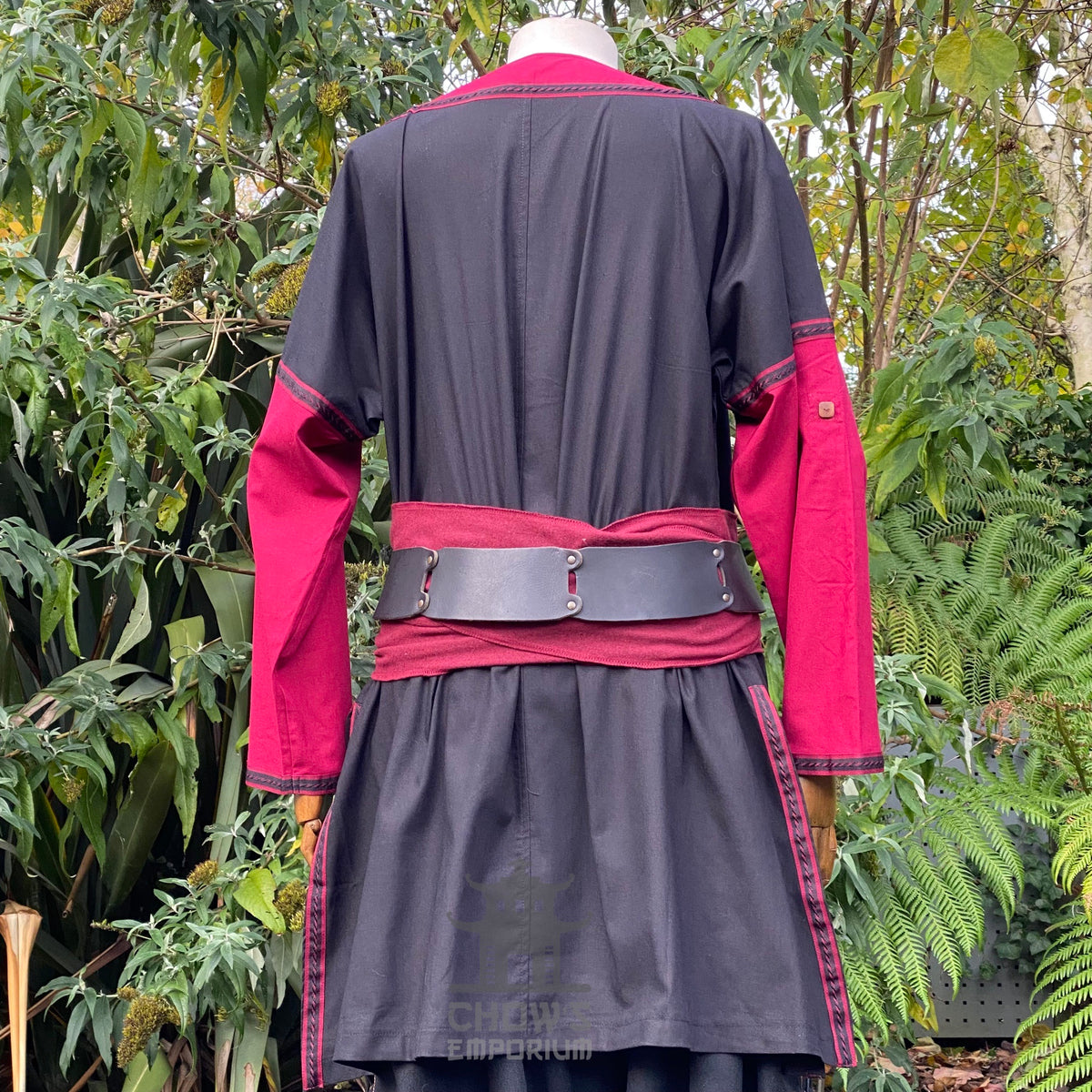 Rear view of medieval LARP outfit; crimson sleeves, black back, leather belt.