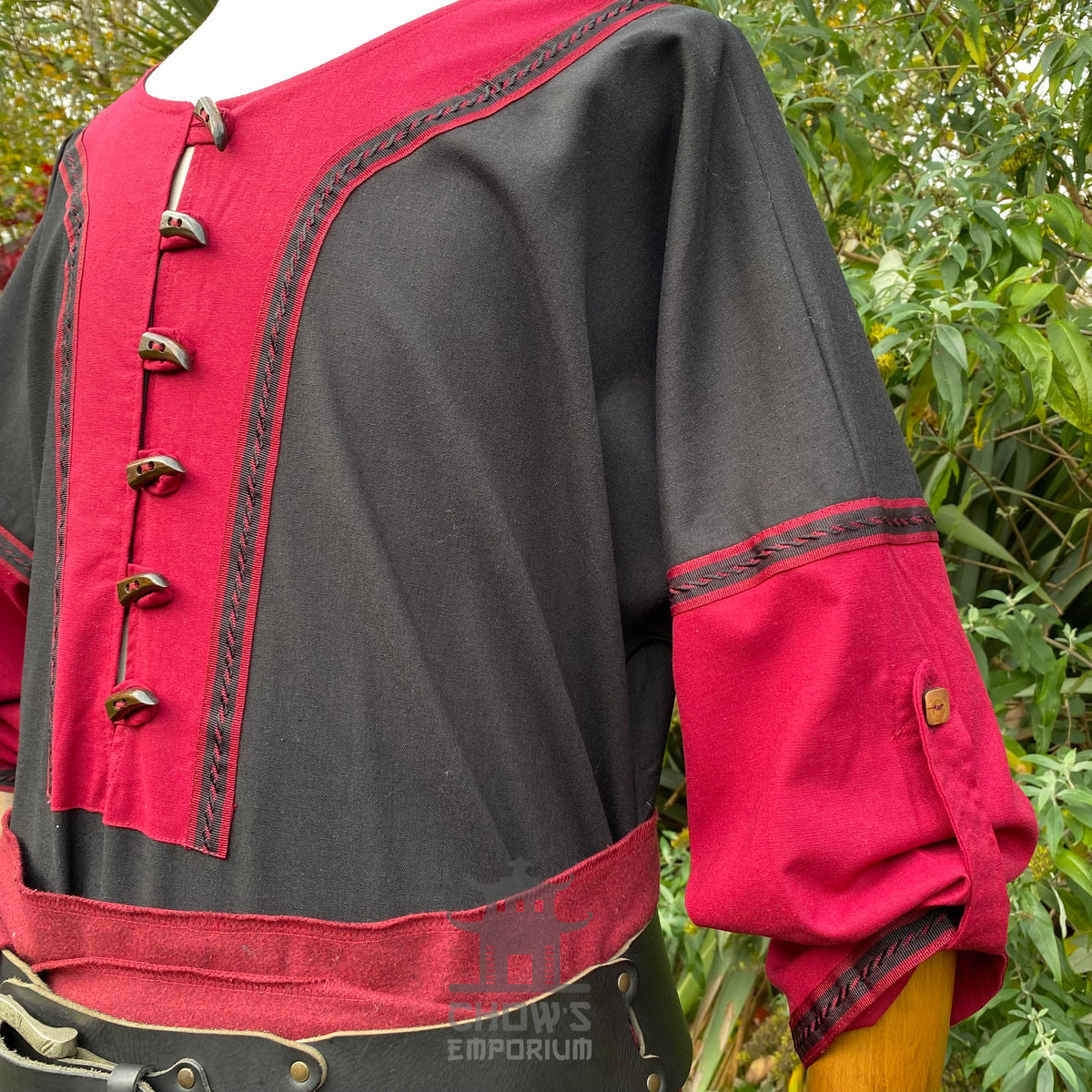 Crimson and black LARP tunic with button detail, close-up shoulder view.