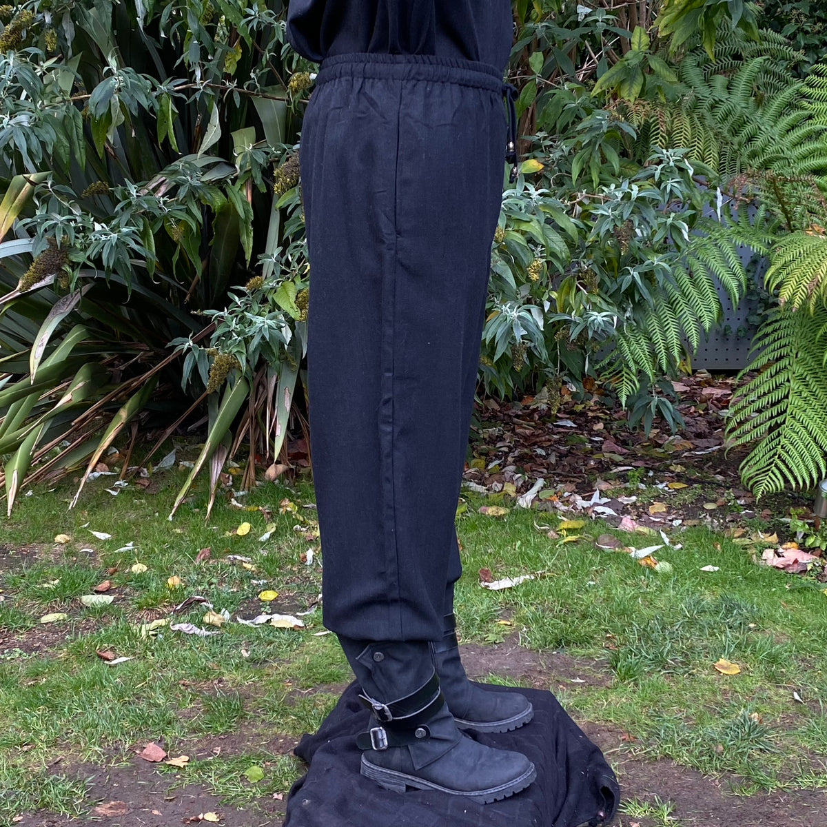 straight-leg medieval trousers in black wool fabric.