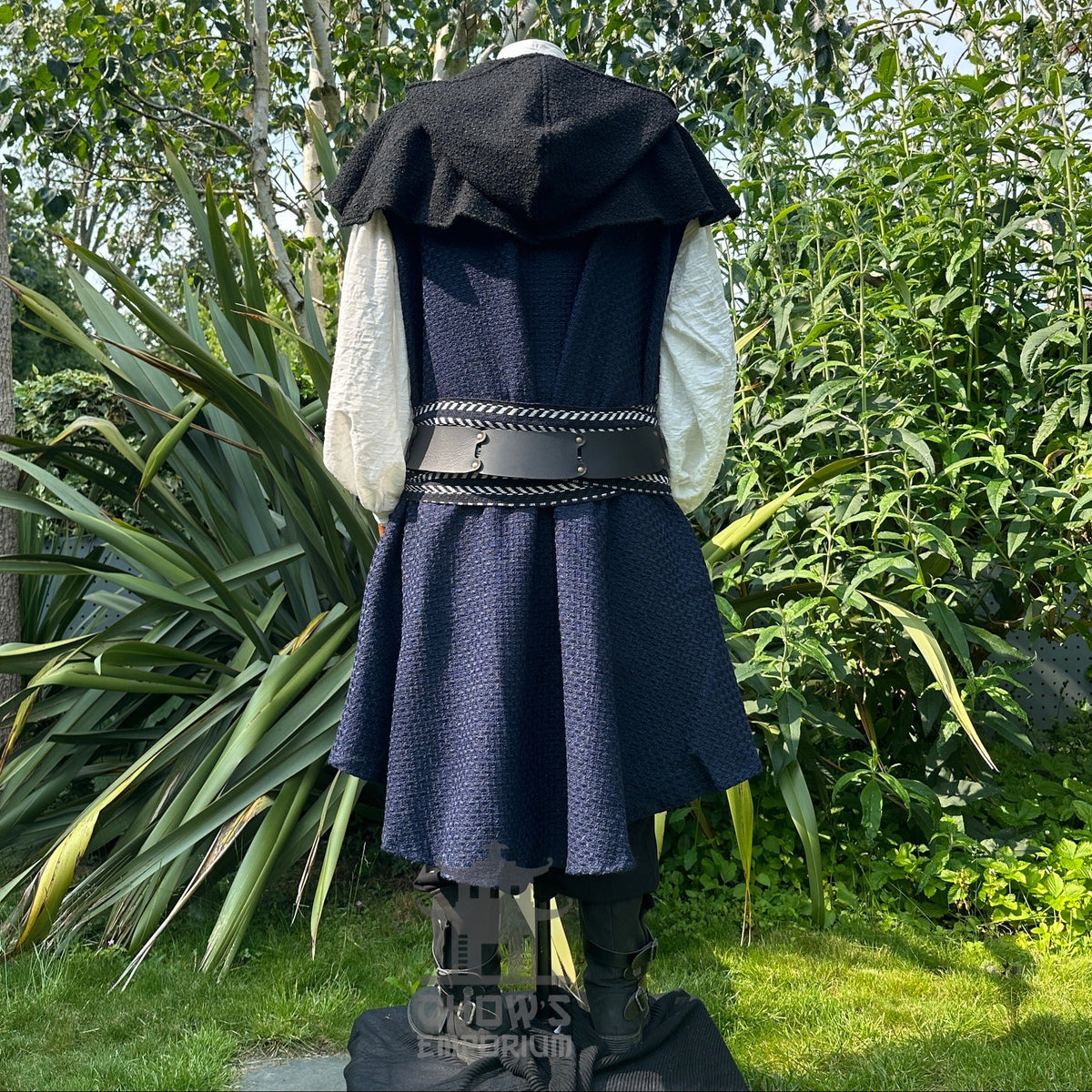 Medieval LARP outfit back view, featuring blue asymmetrical waistcoat, hood, shirt, trousers.