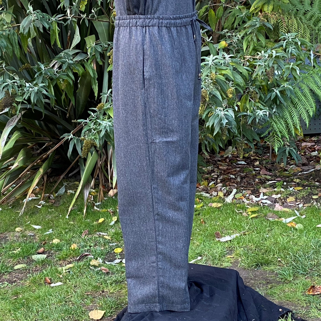 Side view of grey straight-leg medieval pants with wool texture and adjustable cord waist no boots.