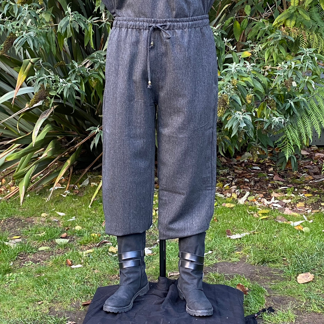 Grey wool medieval pants with drawstring waistband, styled with boots.