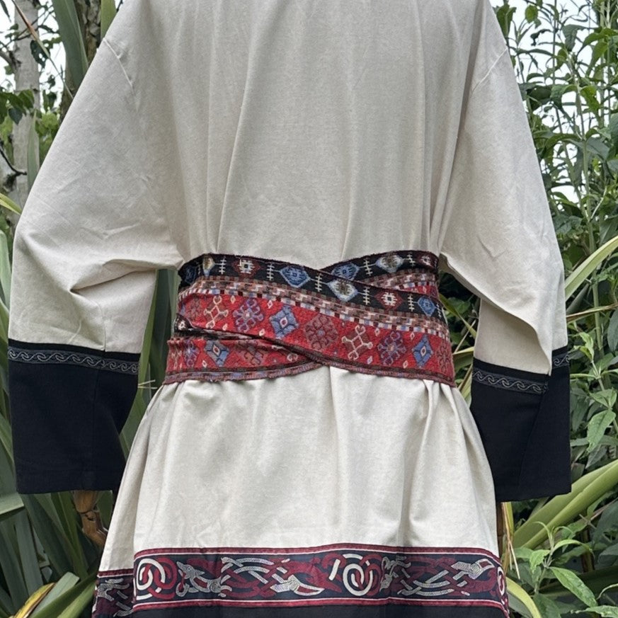 Red Aztec pattern LARP belt and sash on cream medieval tunic, rear view.