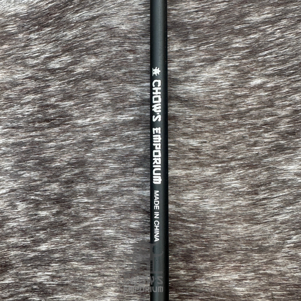 Black LARP arrow shaft with flat foam head, side view on textured background.