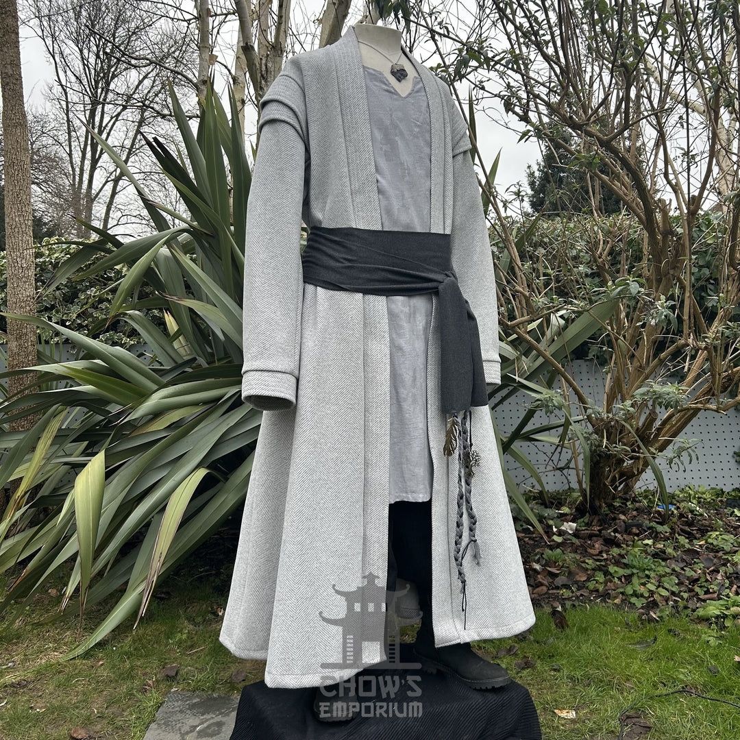 Medieval LARP costume side view, featuring a light grey full length robe, tunic, trousers, and sash.