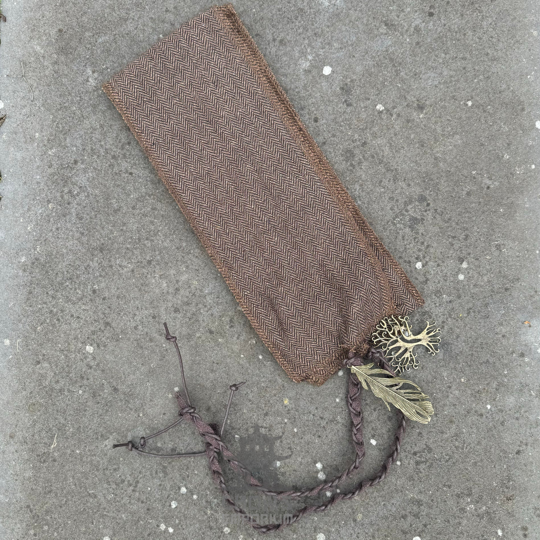 Brown herringbone wrap with braided ties on textured surface, medieval LARP accessory.