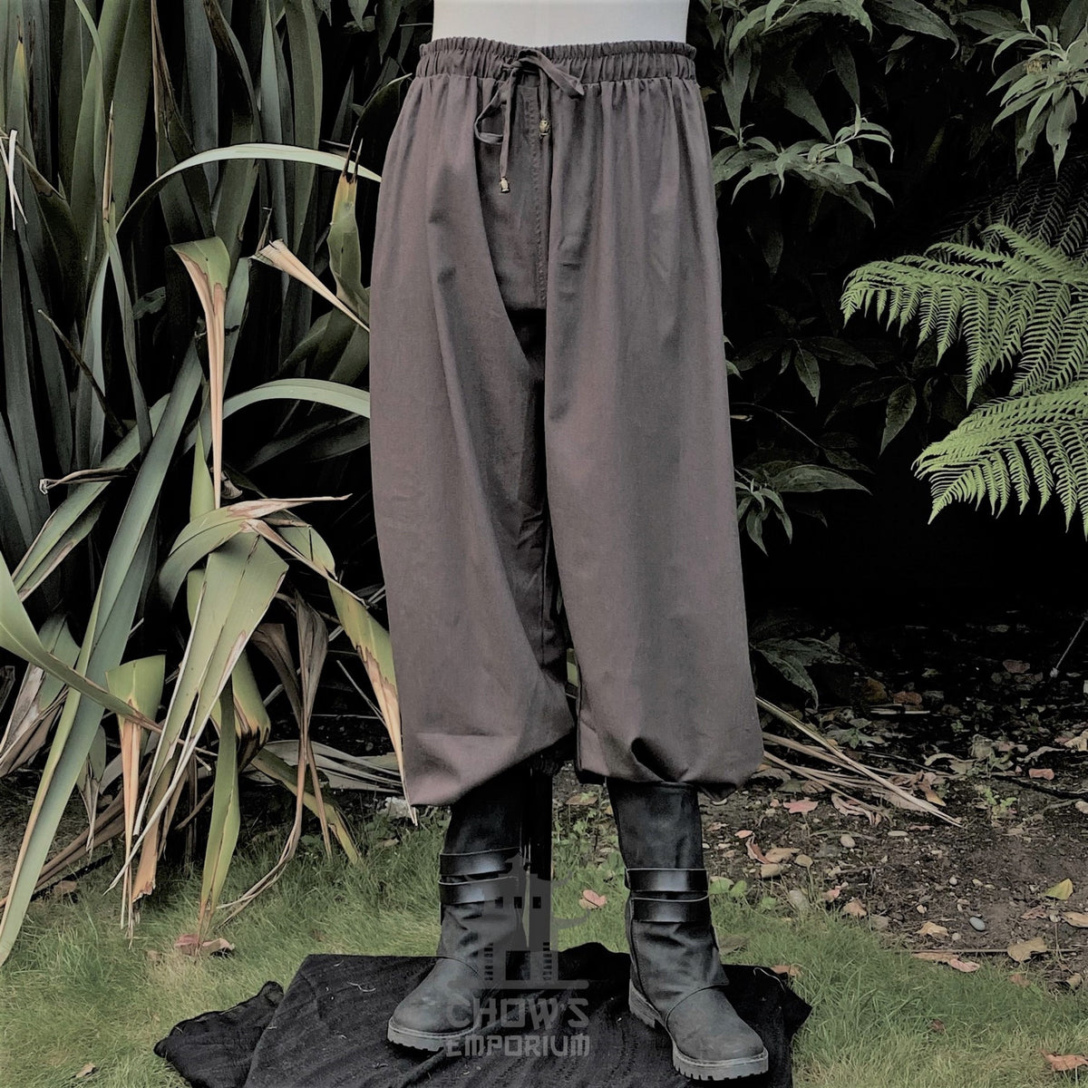 Grey LARP medieval pants with boots, garden background, waist drawstring.