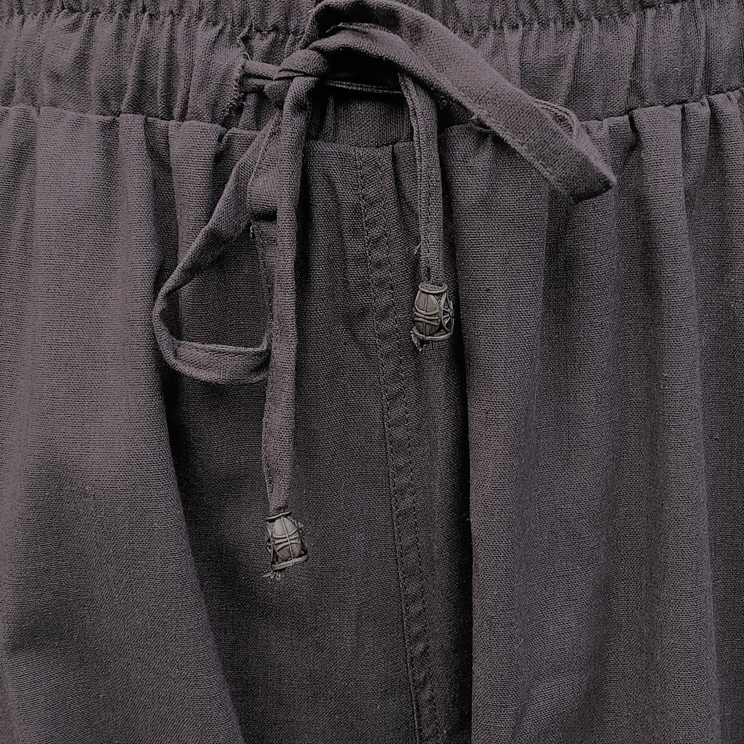 Detail shot of reinforced stitching and fabric texture on grey medieval trousers.