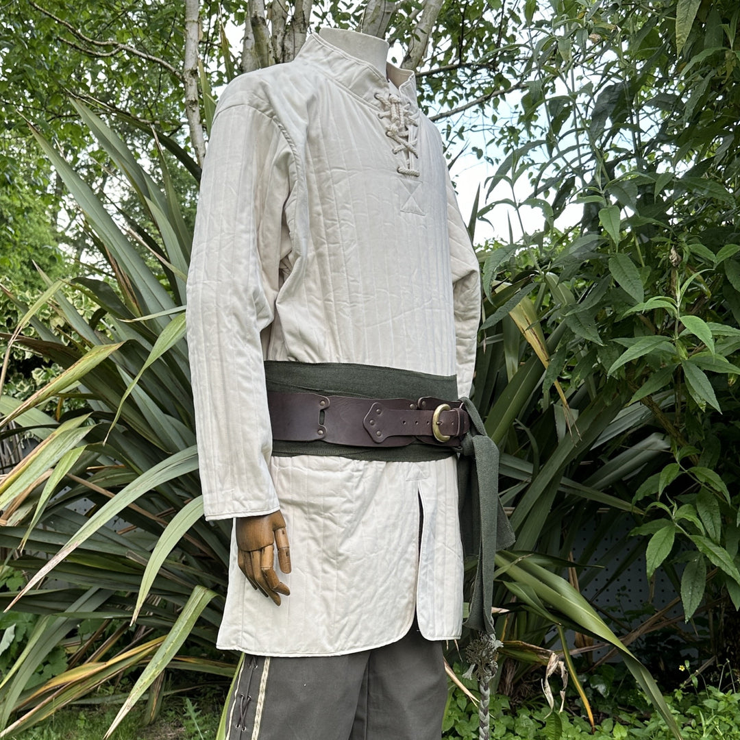 White cotton gambeson for LARP, side view amidst greenery.