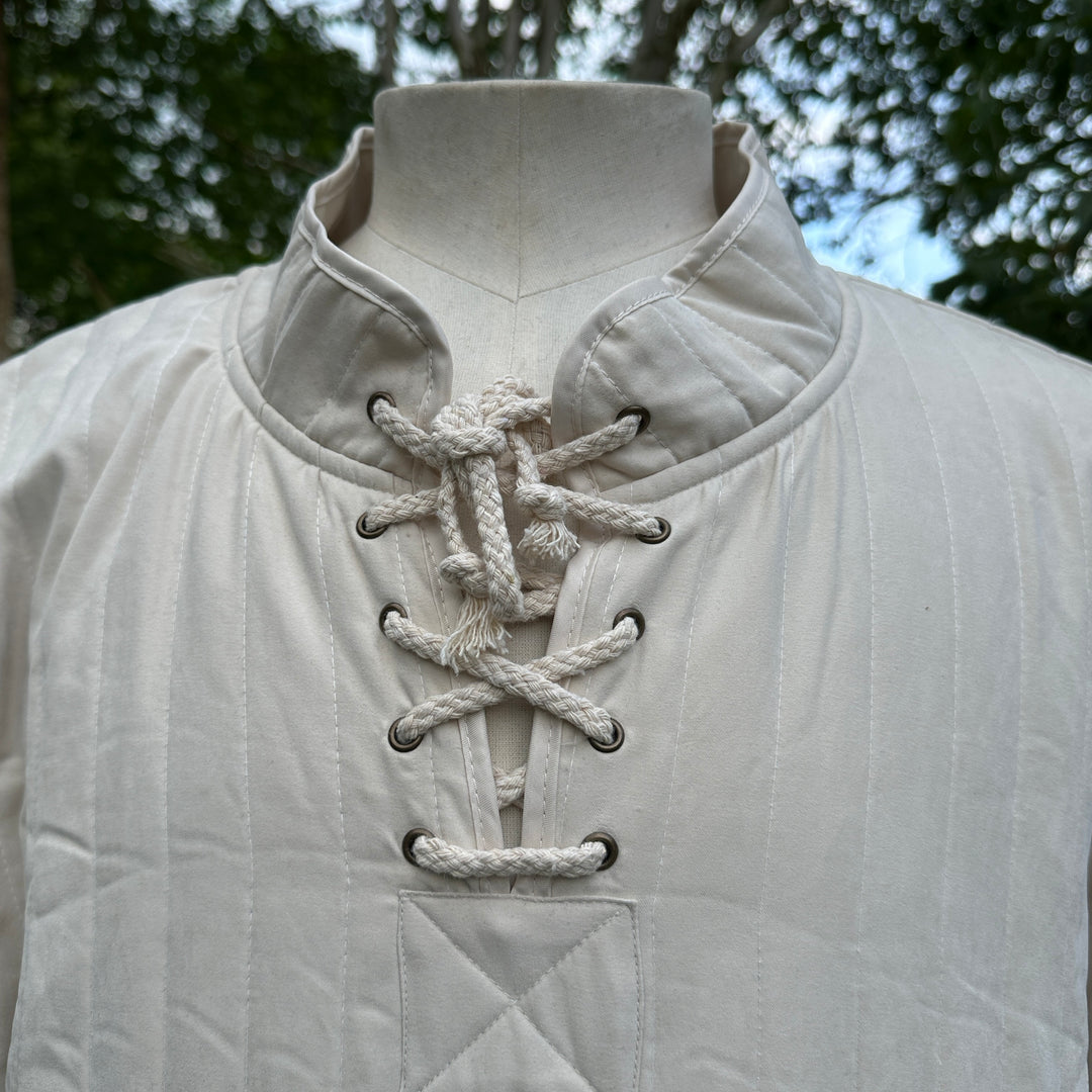 White padded medieval gambeson with rope lacing, front view.