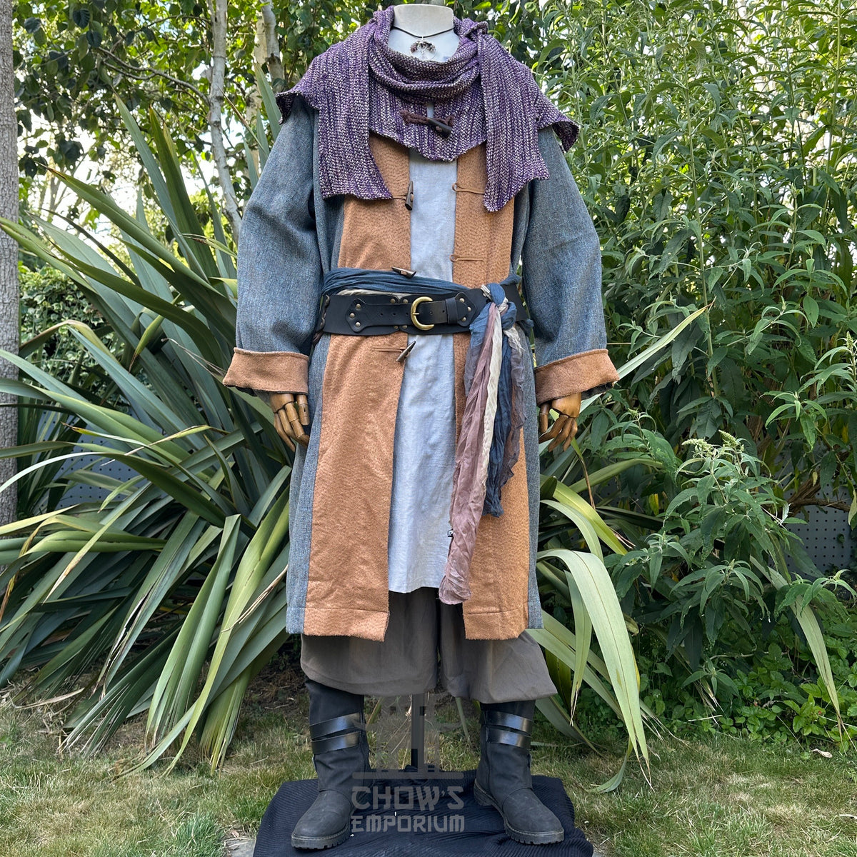 Medieval LARP outfit in garden, featuring layered robe with purple scarf.