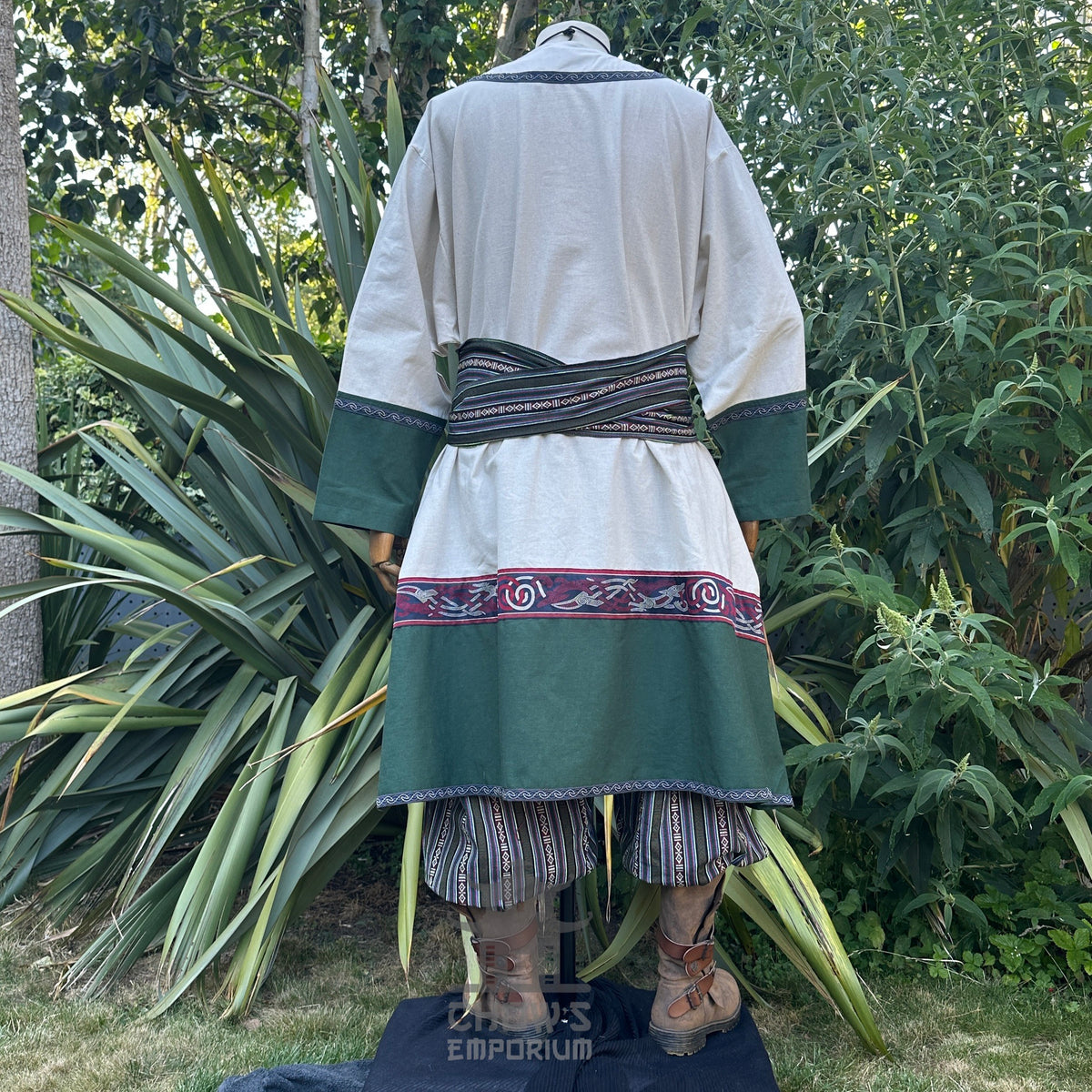 Medieval LARP outfit back view, featuring a white and green tunic, striped trousers and matching.