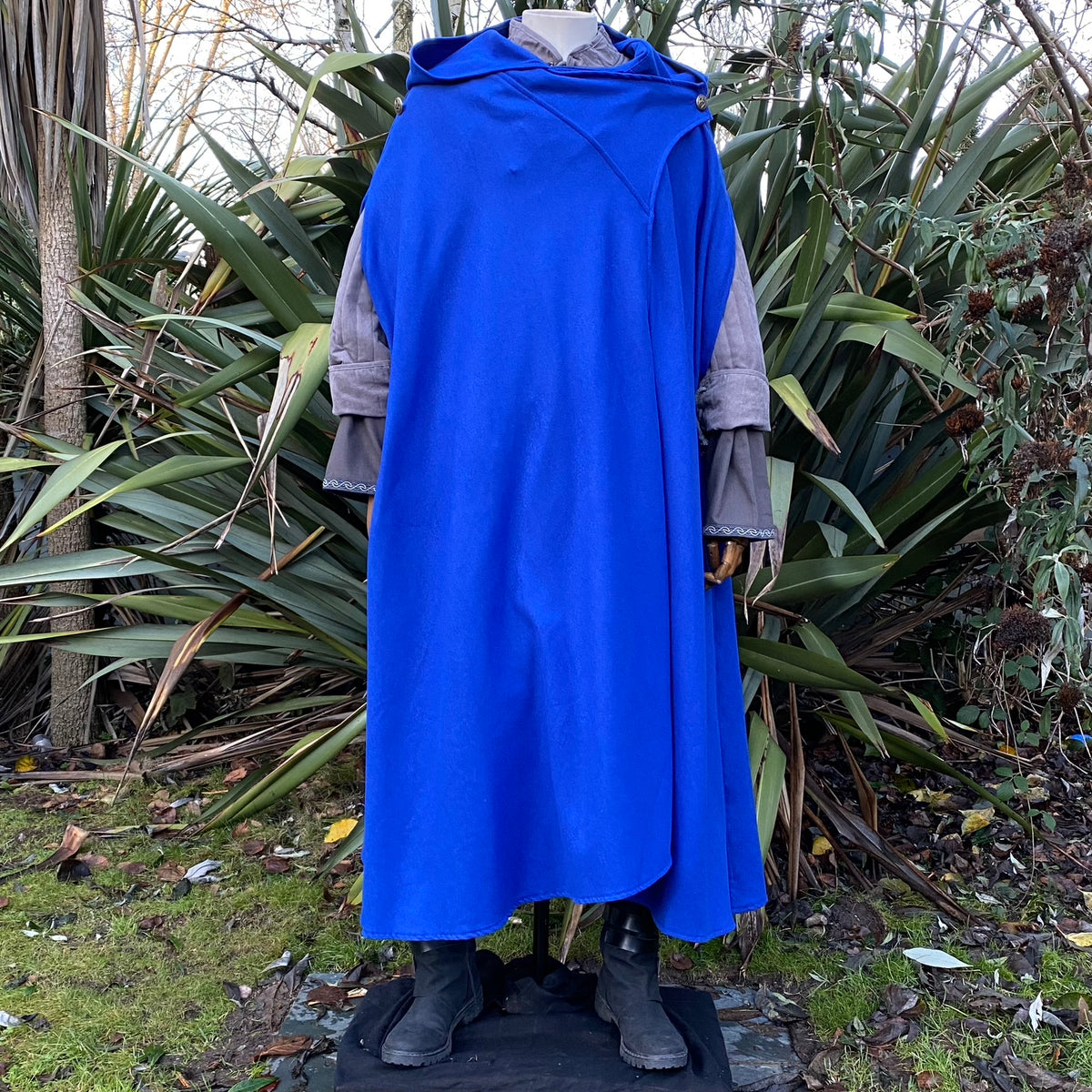 Mannequin in royal blue Viking cloak, garden setting for LARP or medieval events.