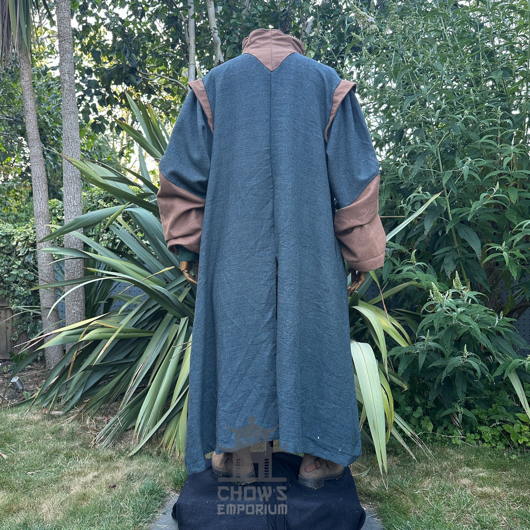 Medieval LARP costume back view featuring teal robe, tunic, pants, belt, sash and necklace.
