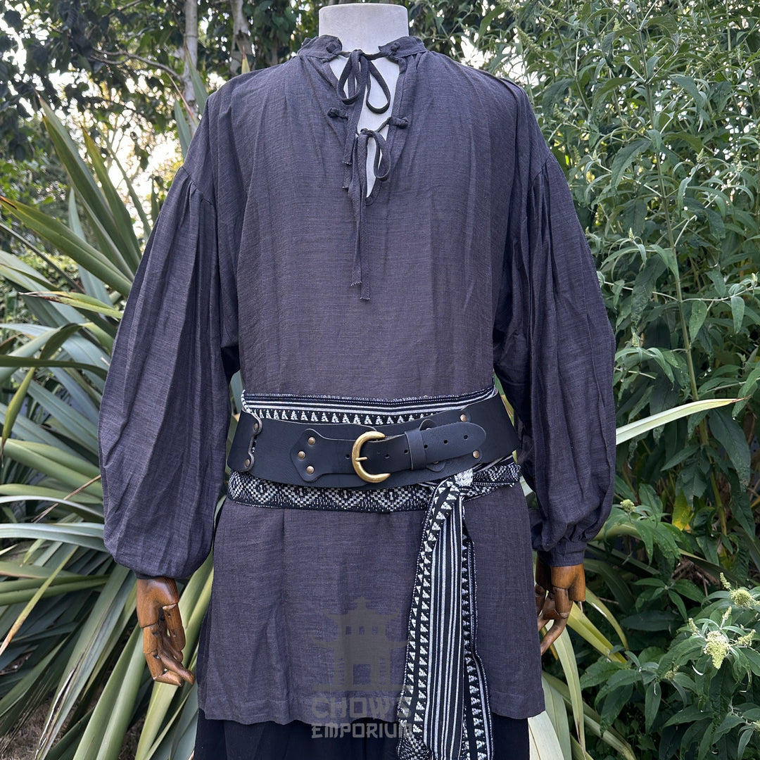Medieval necromancer LARP attire, grey shirt, black belt, patterned sash.