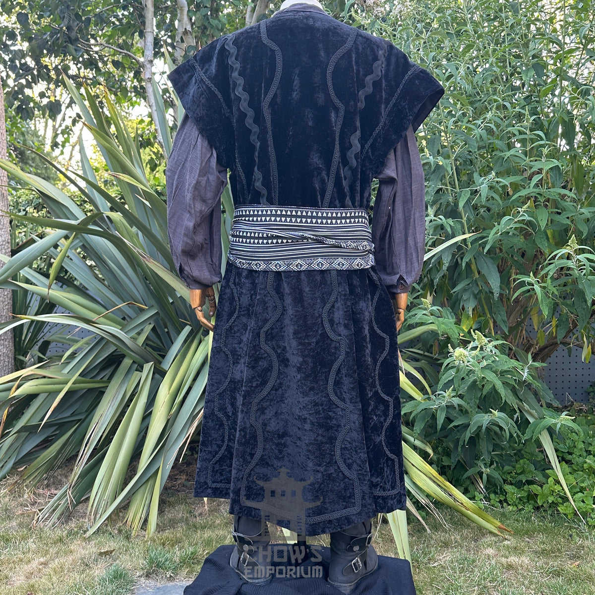 Medieval LARP costume back view featuring a black suede-effect waistcoat, grey shirt, and sash.