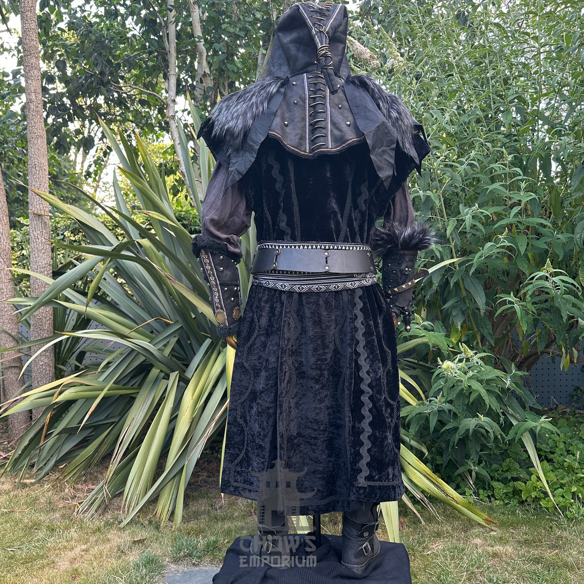 Medieval LARP costume back view featuring waistcoat, hood, vambraces, shirt, trousers, belt, and.