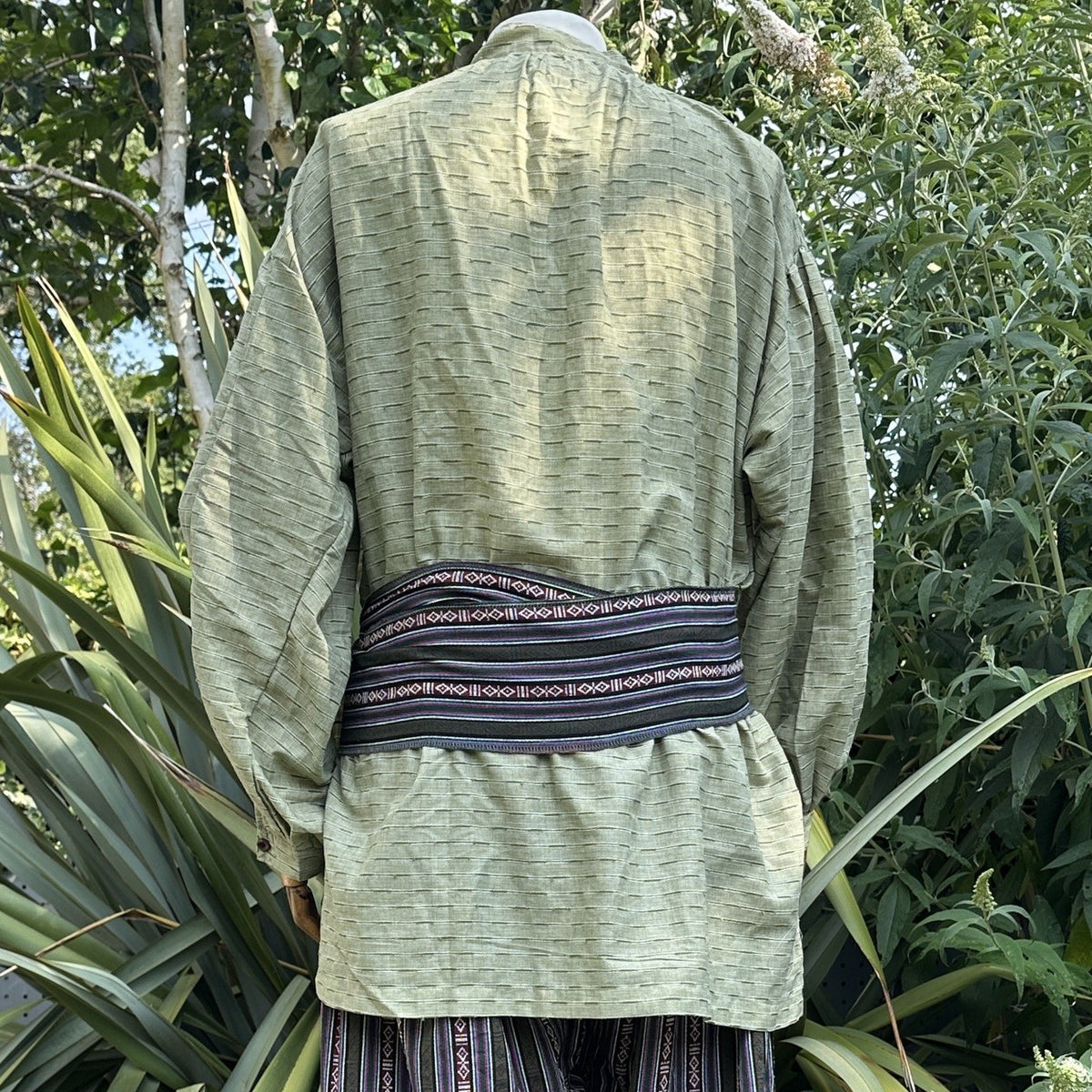LARP medieval outfit, back view of green shirt, striped pants and sash.