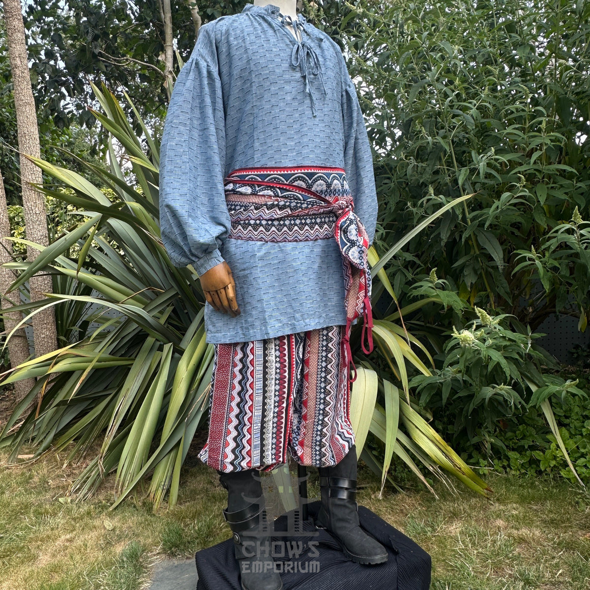 Blue medieval shirt, red zigzag pants, sash for LARP, side view.