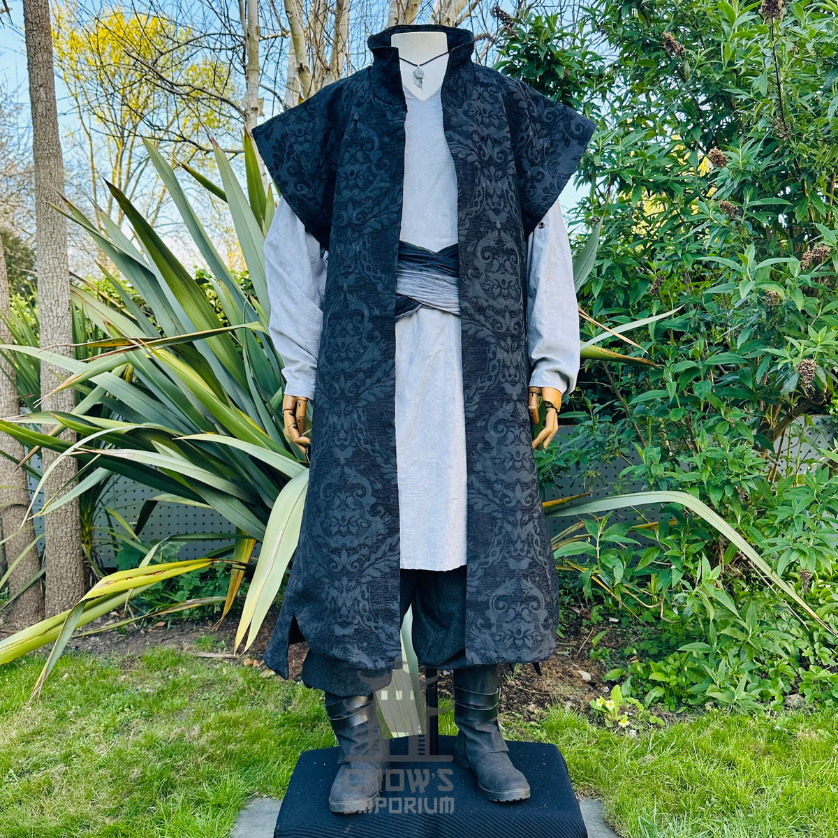 Black brocade warlock waistcoat worn open over a grey cotton tunic