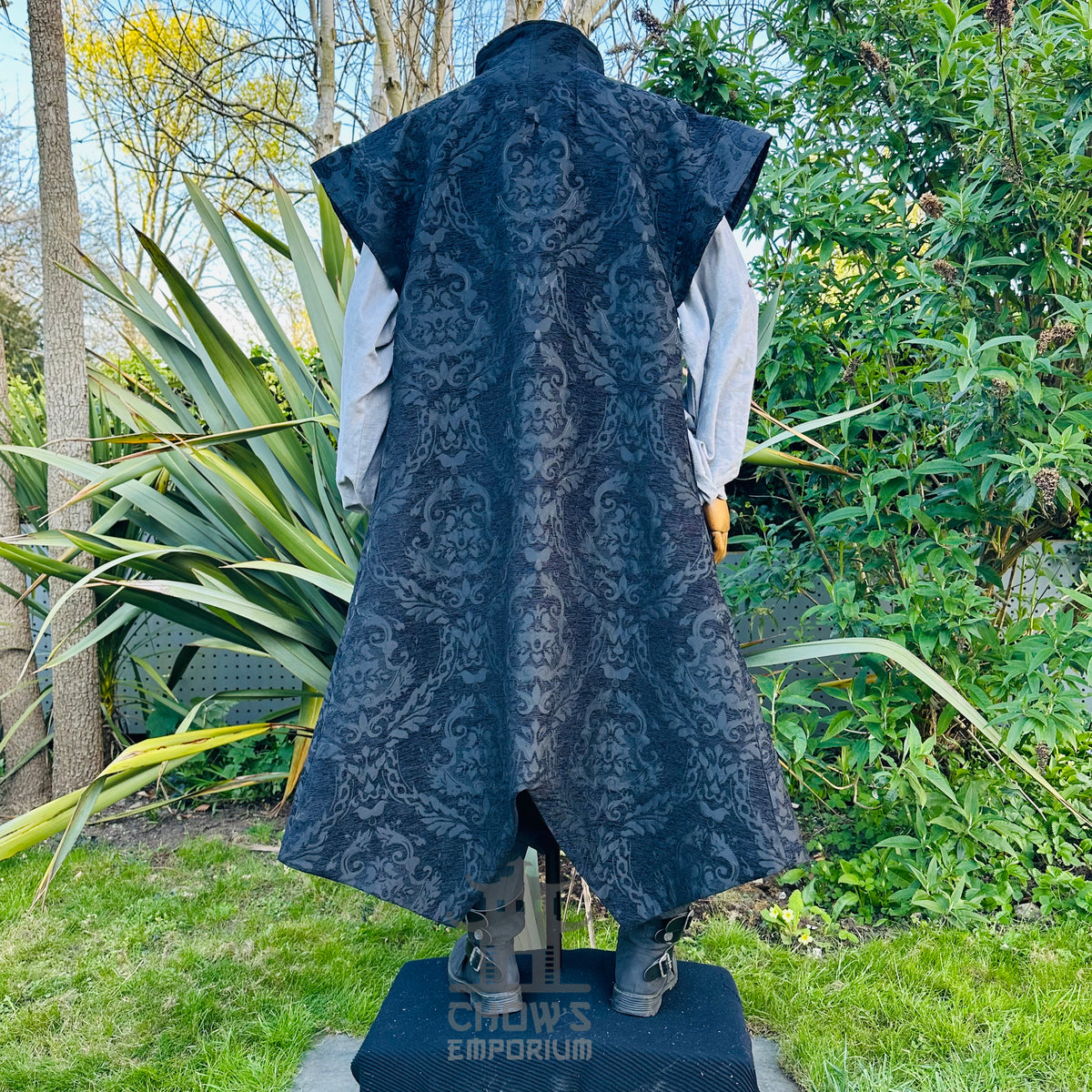 Back view of the black brocade waistcoat with a long tailcoat hem, worn over a white shirt
