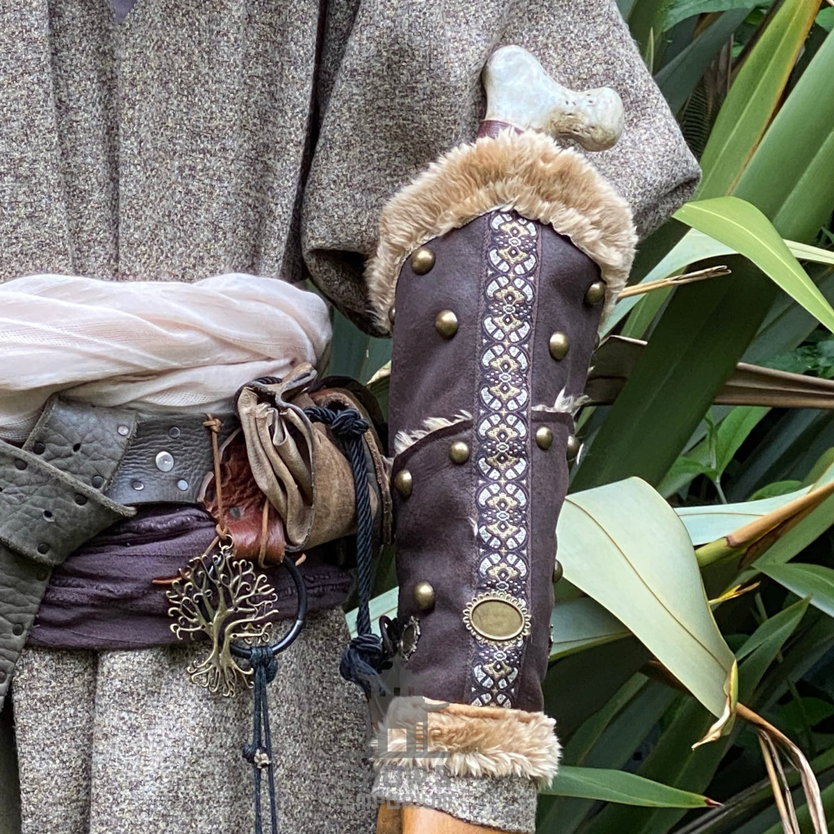 Brown leather vambrace with fur trim and ornate design.