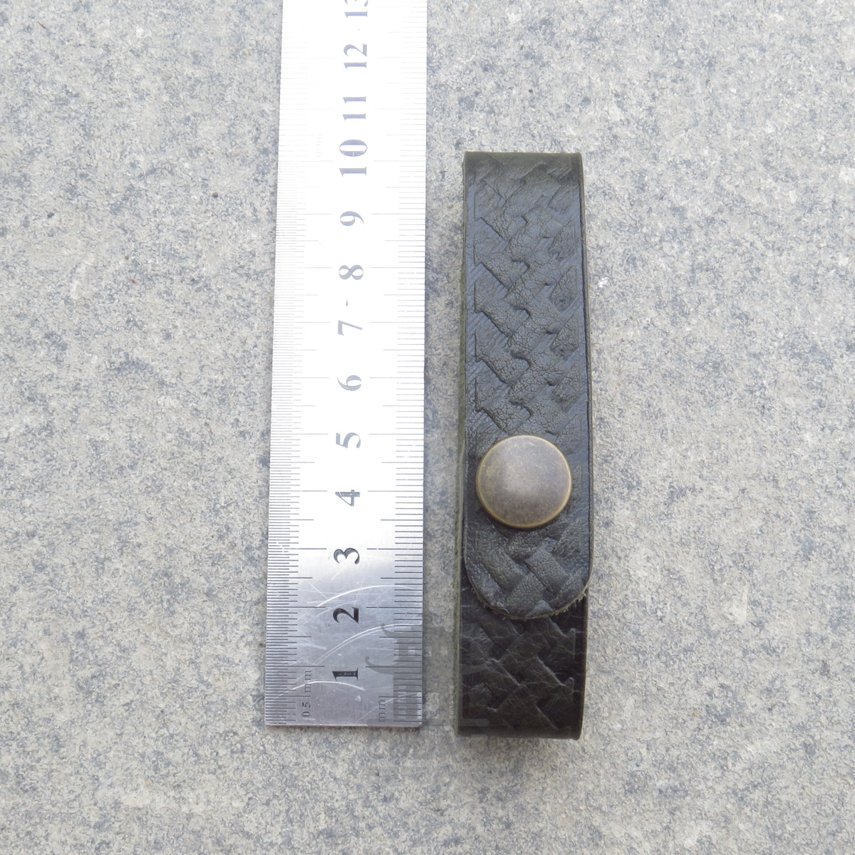 Celtic knot leather tankard loop measured against a ruler at 25.5cm