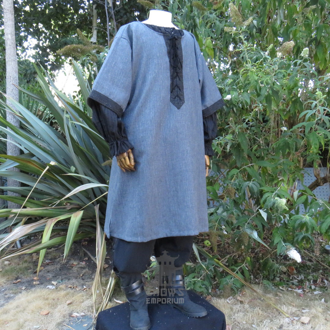 Grey woven medieval tunic, side view showing the drape of the body and the black cuffs.