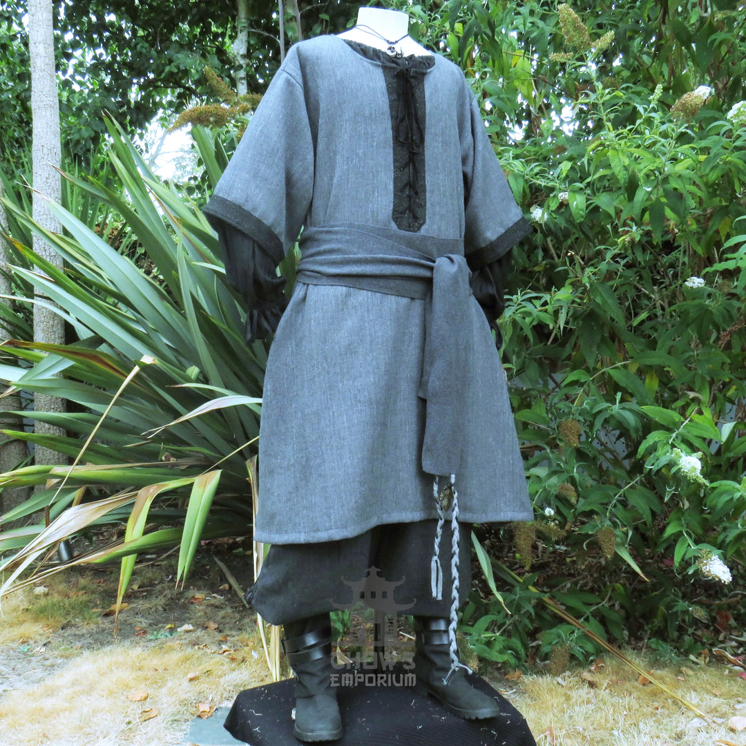 Grey and black woven medieval tunic worn loose, side view showing the black lace-up chest panel and short sleeves.