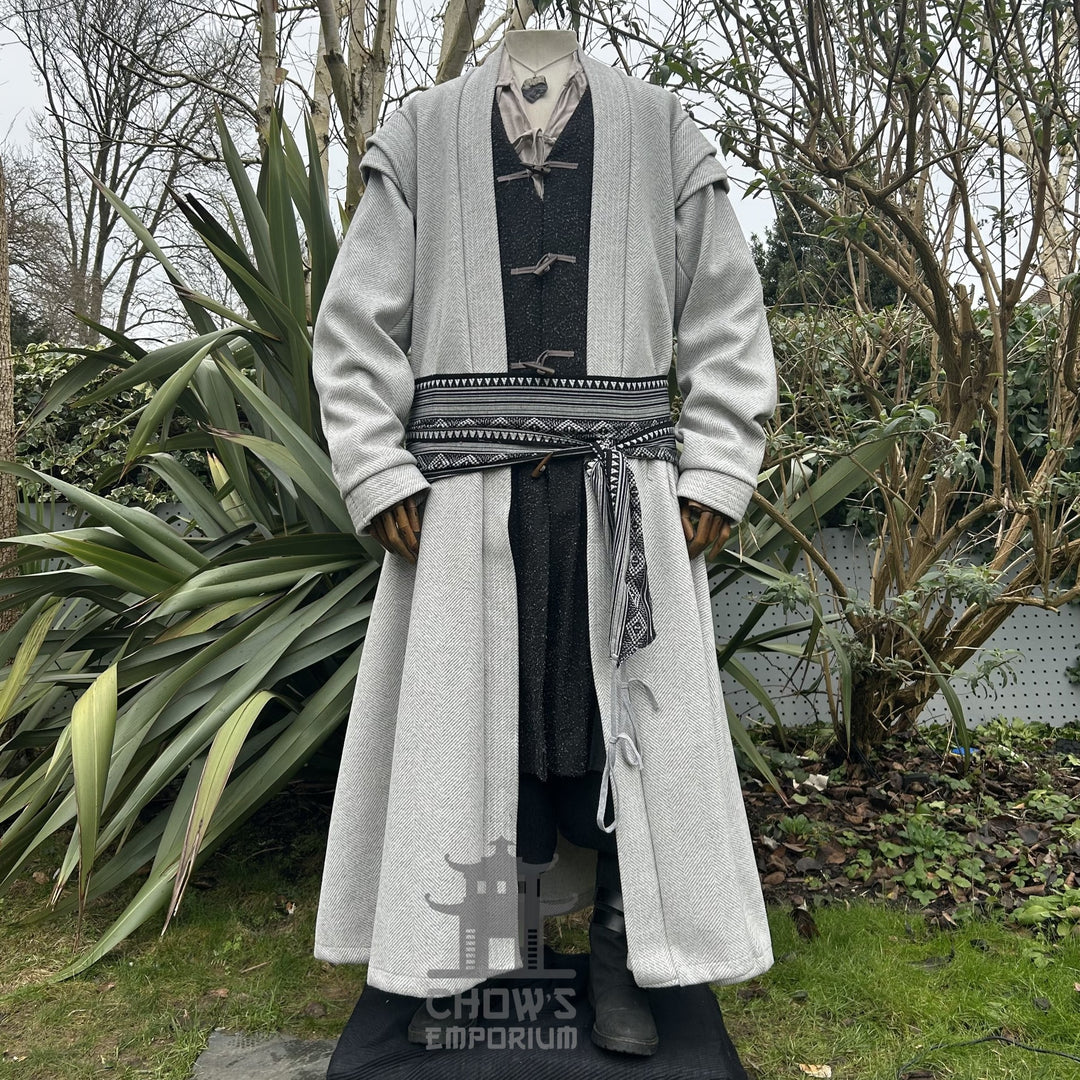 A light grey full-length robe featuring a herringbone pattern with patterned sash, displayed on a mannequin, shown from front view, in a garden setting.