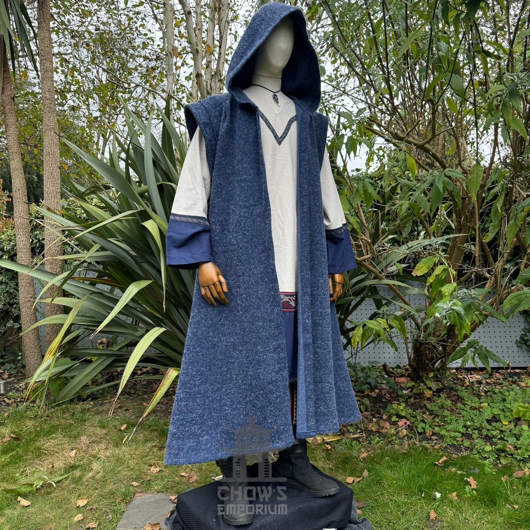 Mannequin wearing an open blue robe with hood up in an outdoor setting with greenery.
