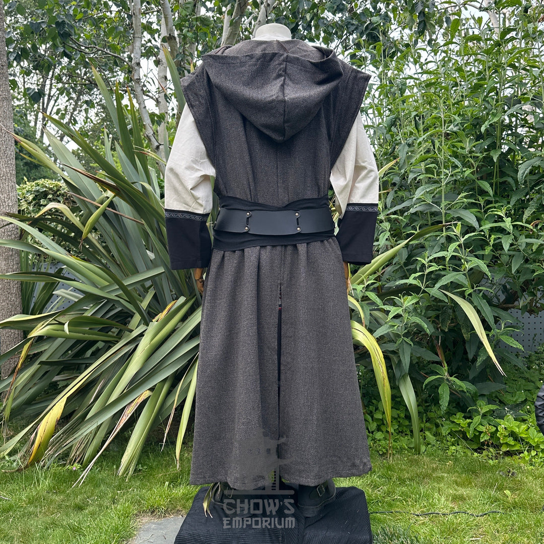 Back view of mannequin in brown herringbone sleeveless robe with hood down, in garden setting.