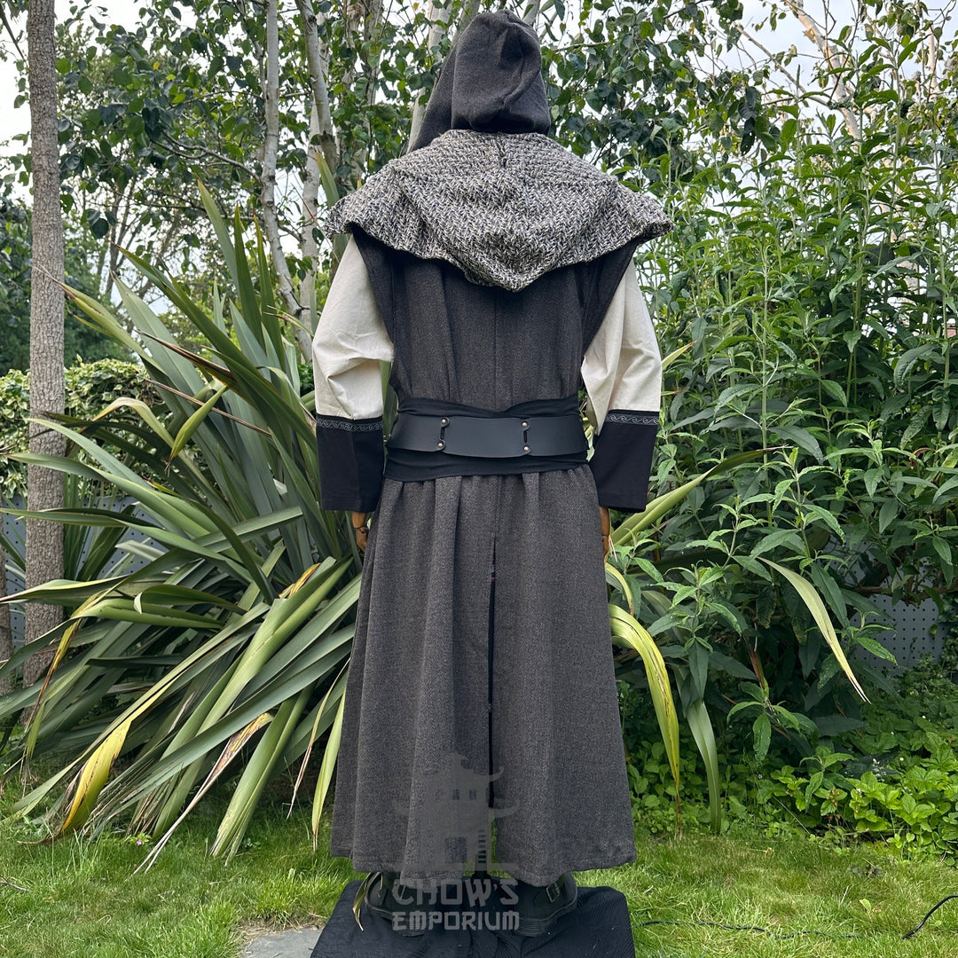 Back view of mannequin wearing hooded brown herringbone sleeveless robe with scarf hood, in garden setting.