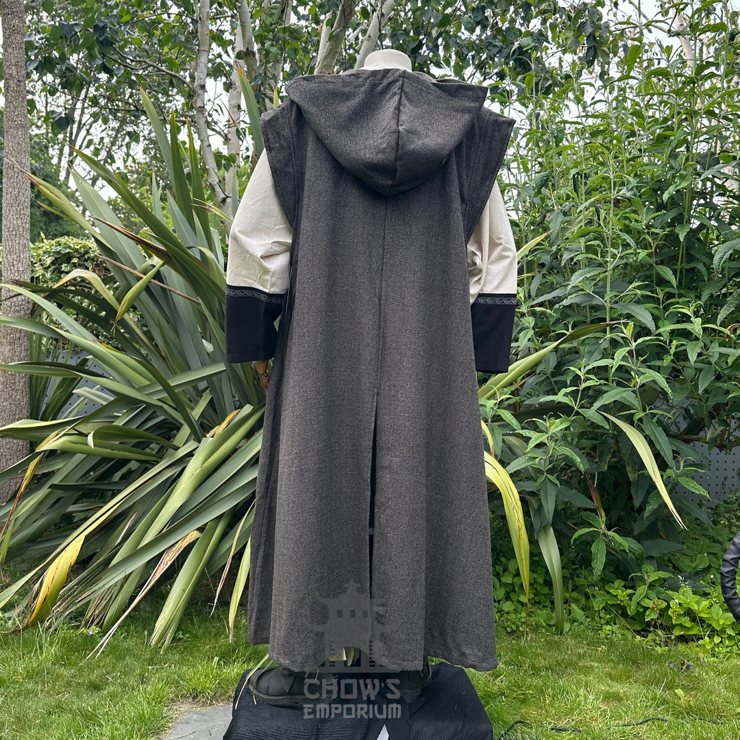 Back view of mannequin in full length, hooded brown herringbone sleeveless robe, in garden setting..