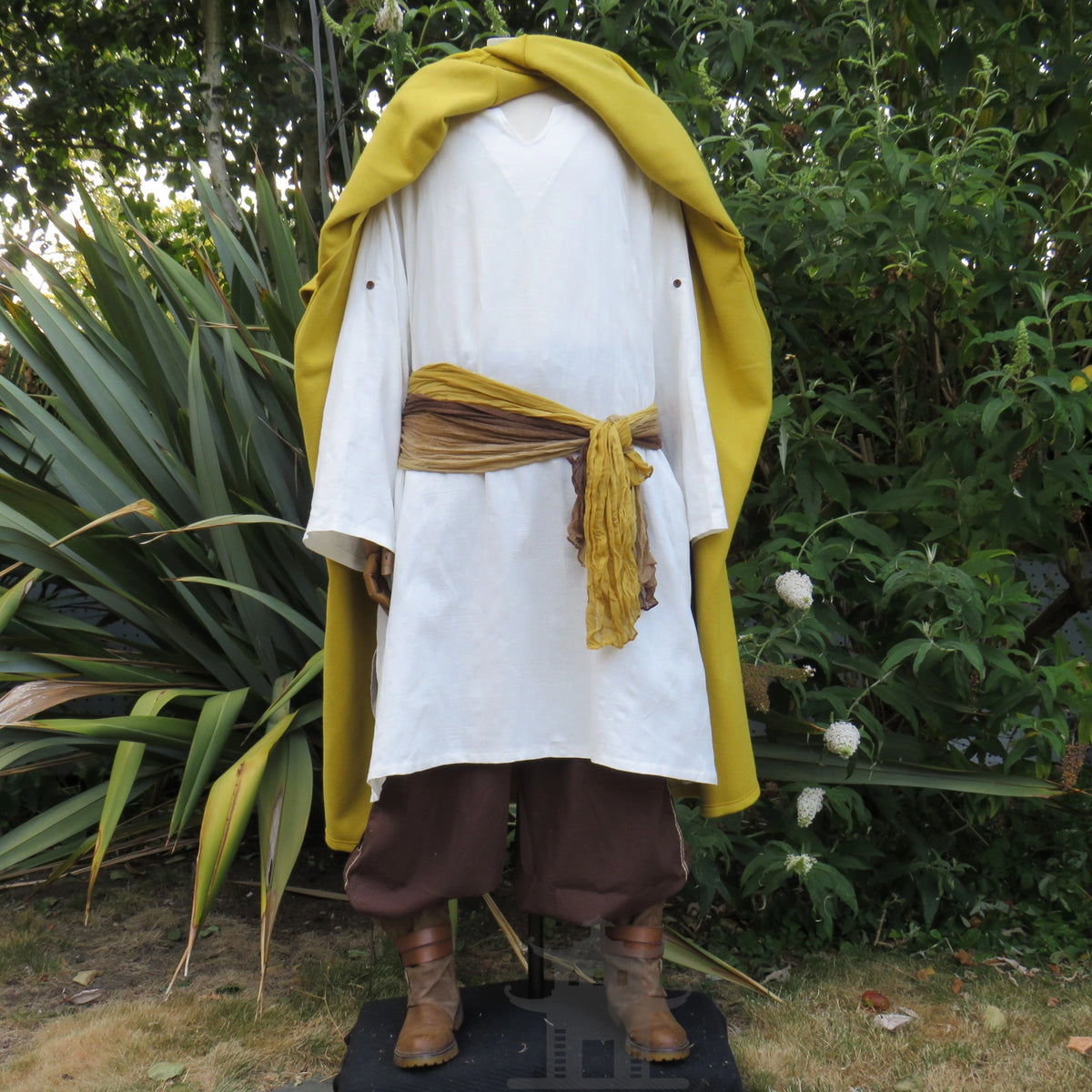 Mustard wool cloak worn open, showing the shirt and sash beneath
