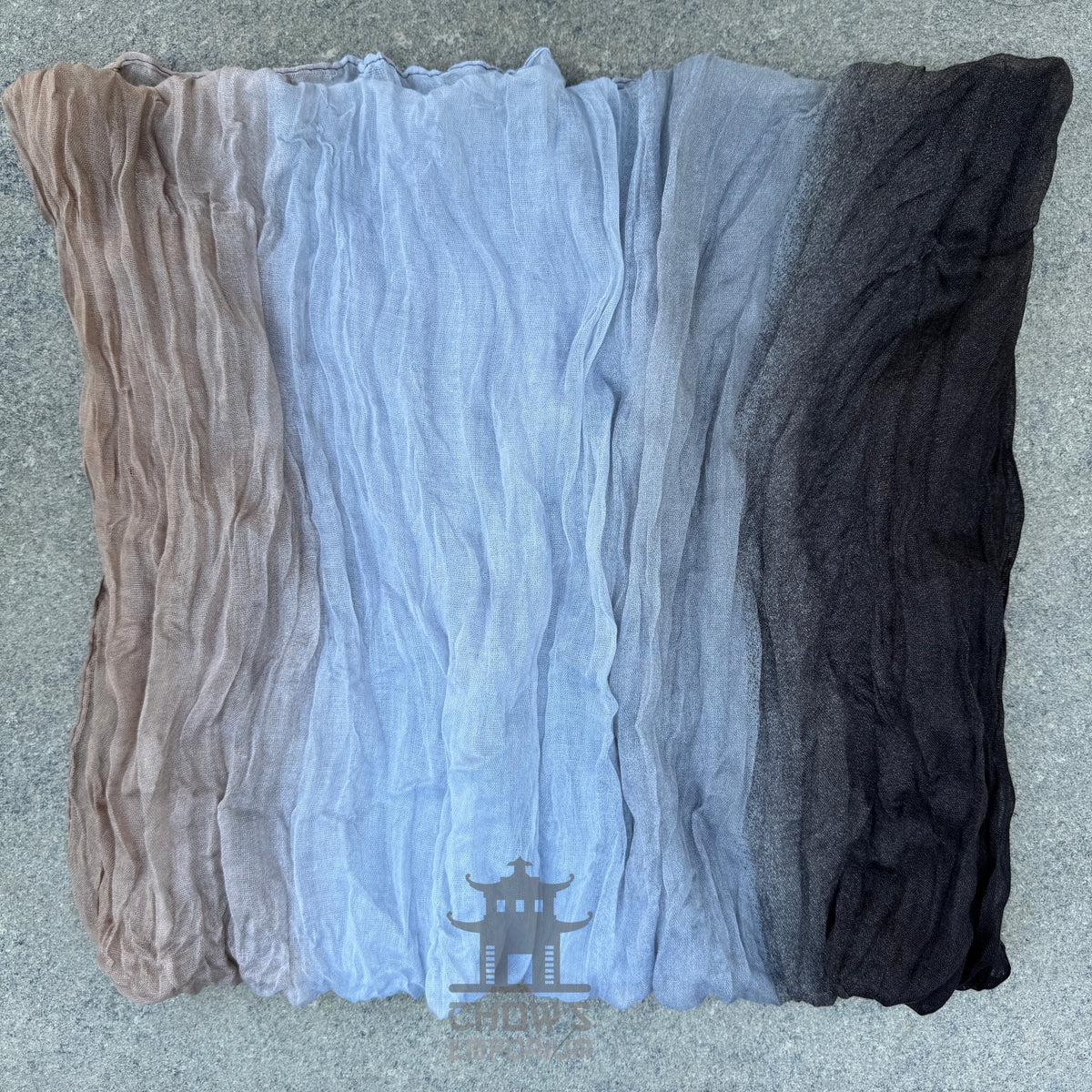 Folded Pebble pirate sash showing grey, white, brown and blue tones