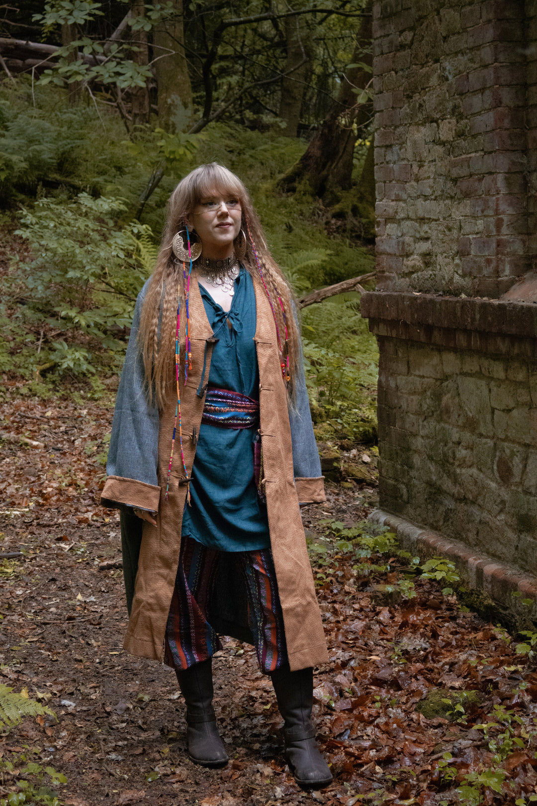 Teal pirate coat in medieval LARP woodland scene, side view of boots.