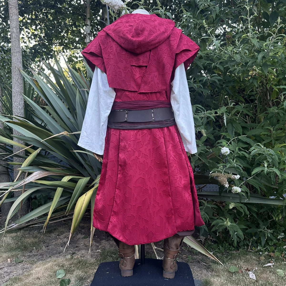 Red waistcoat and hood set with the hood worn up, three-quarter view showing the wraparound hood.