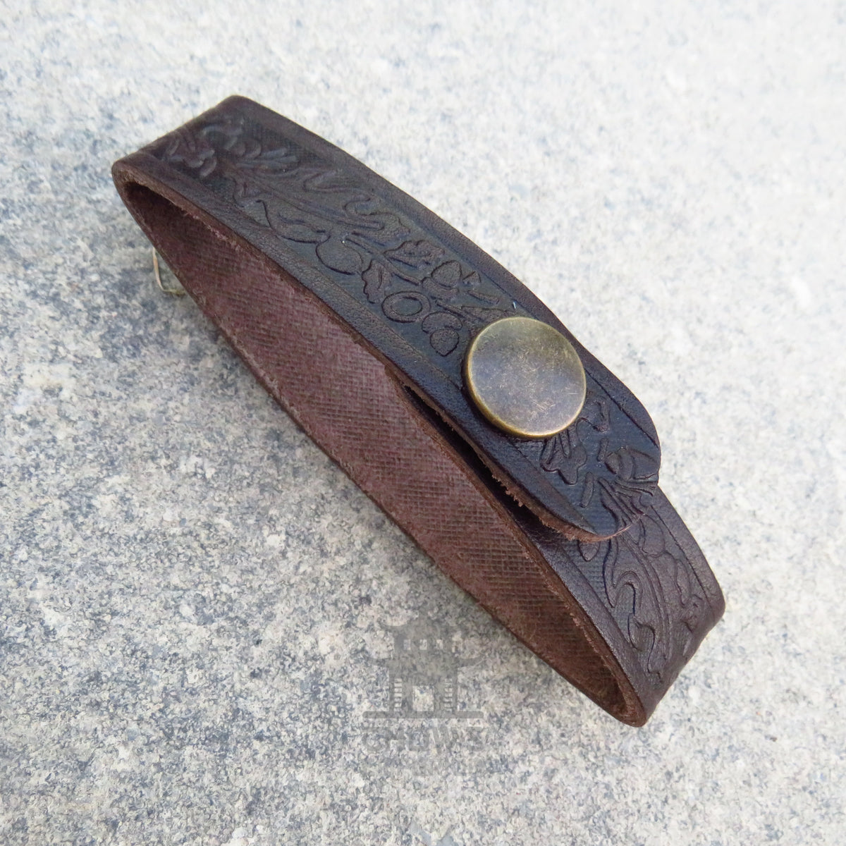 Metal popper fastening on the leather tankard loop
