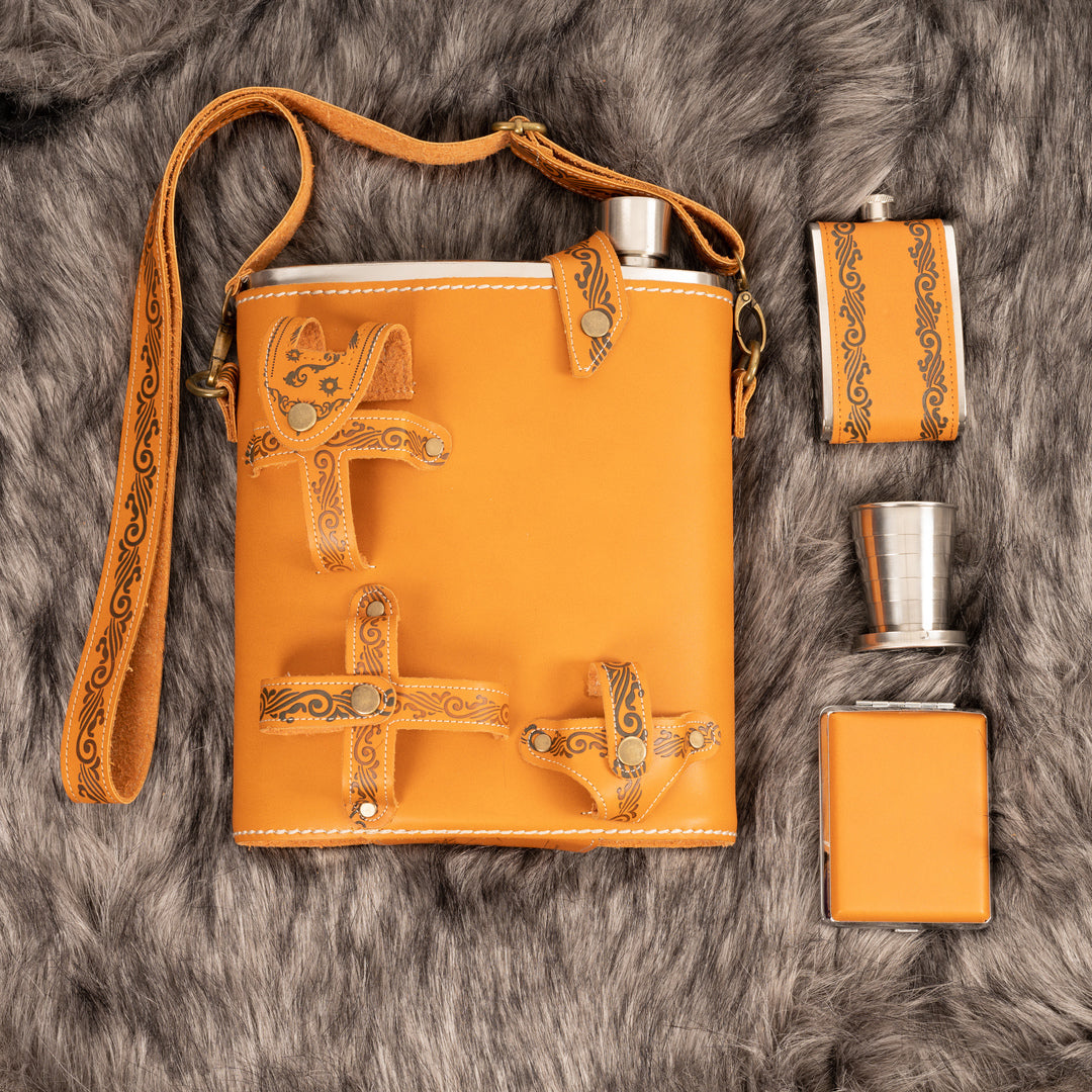 Ornate leather medieval hip flask set with cups on faux fur background.