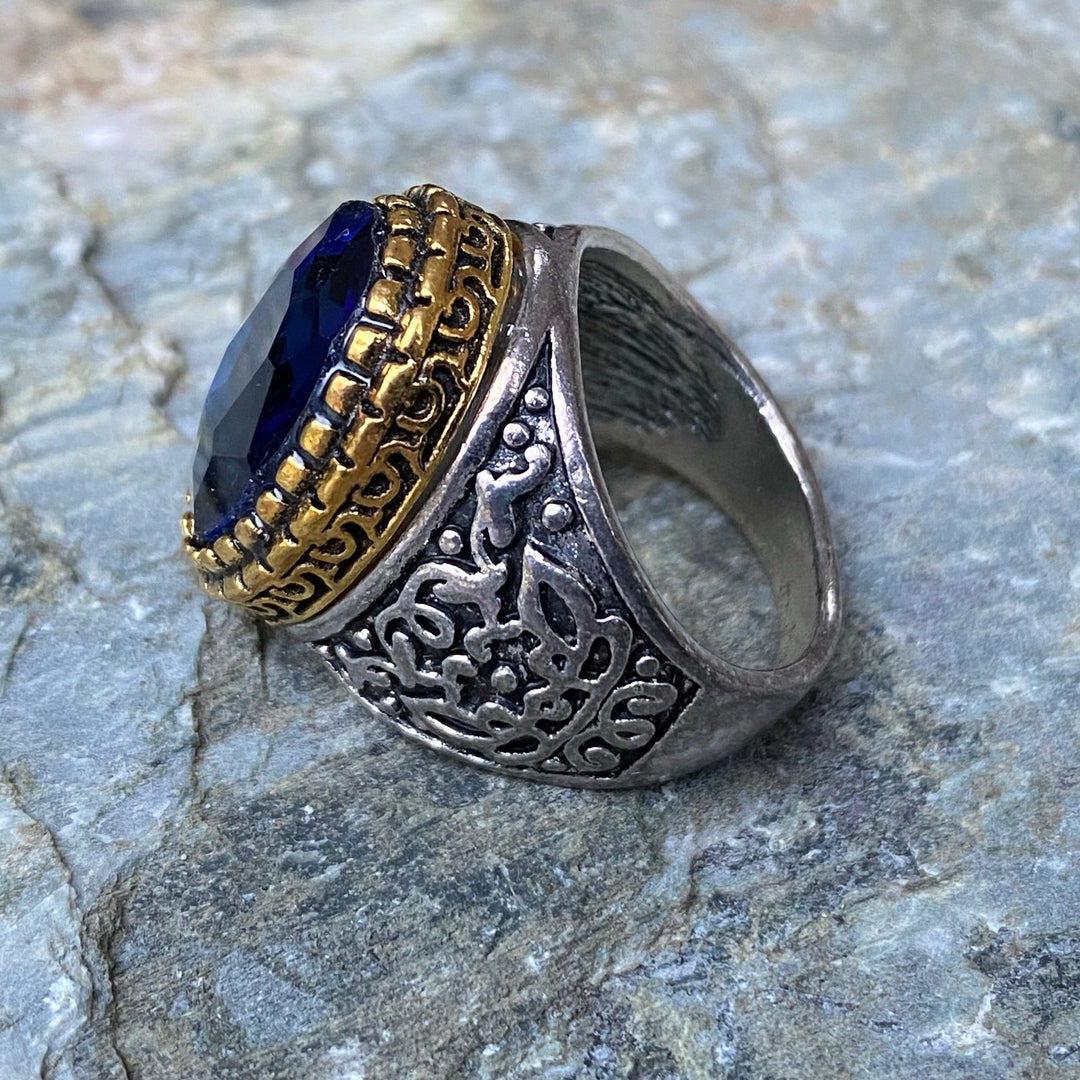Silver ring with intricate patterns and dark blue gem for medieval LARP.