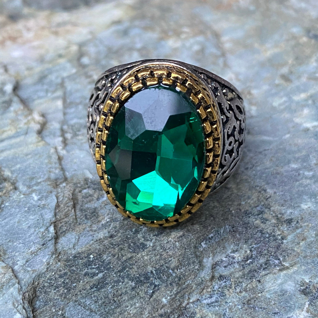 Silver and gold ring with green gemstone on stone for medieval LARP.