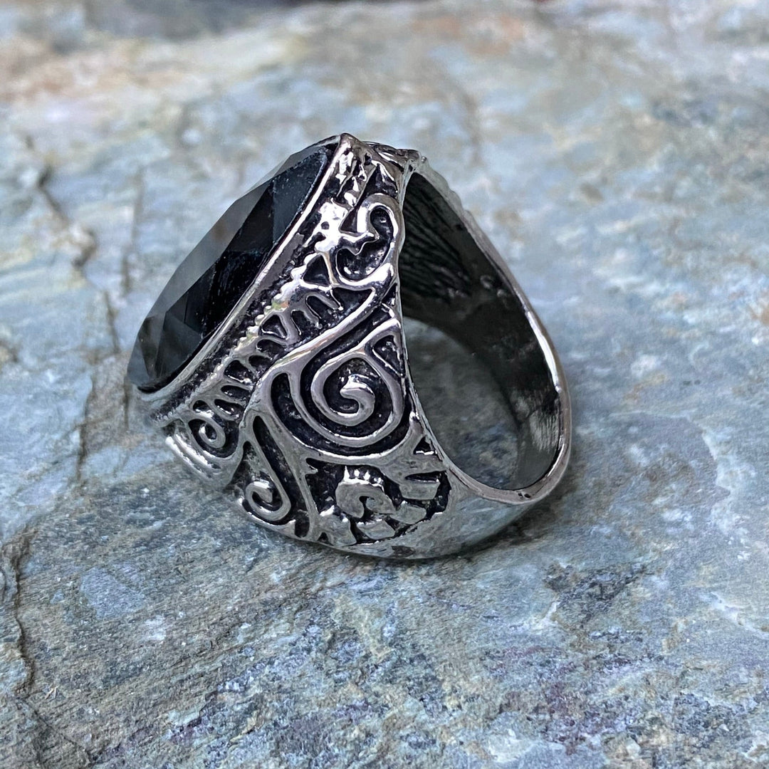 Intricate LARP ring with side view of black oval gemstone and ornate design.
