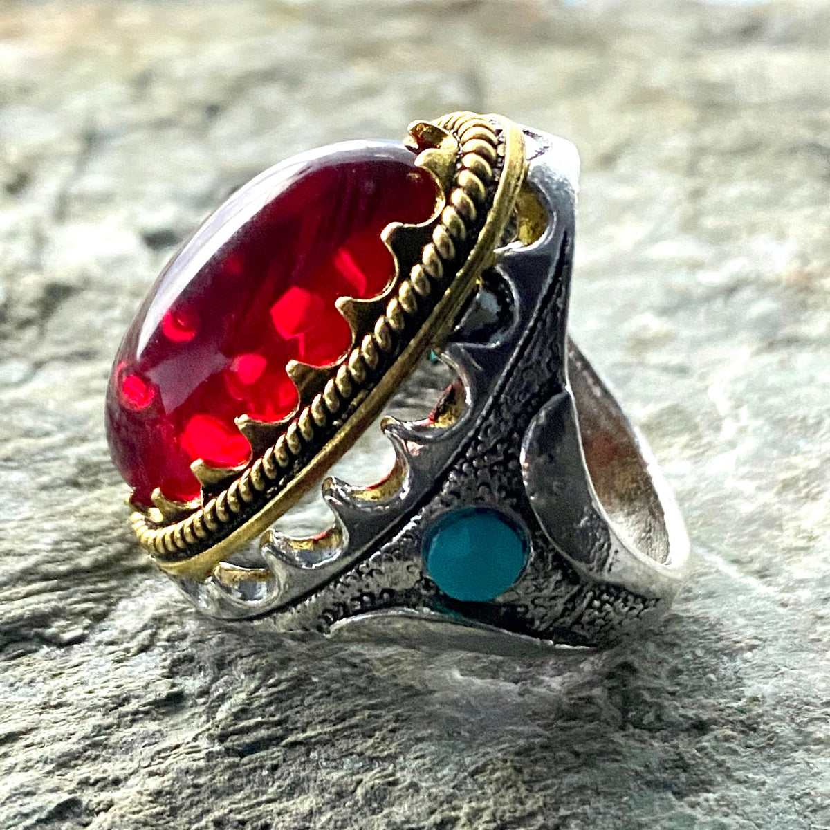 Silver and gold ring with red gem, side view, medieval LARP accessory.